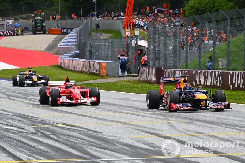 Patrick Friesacher conduit une Red Bull RB8 Renault de 2012 dans une parade des légendes, devant Gerhard Berger, ex-Michael Schumacher Ferrari F2002 de 2002 et David Coulthard, Red Bull RB1 de 2005.