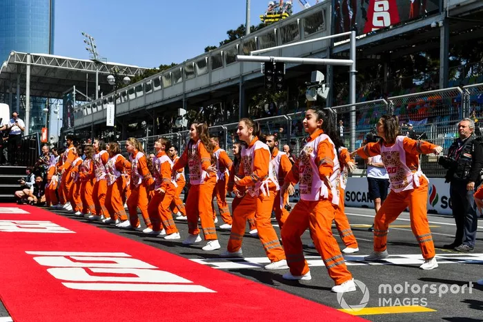 Oficiales de pista bailan antes de la carrera