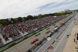 Sebastian Vettel, Ferrari SF71H, voor Valtteri Bottas, Mercedes AMG F1 W09, Max Verstappen, Red Bull Racing RB14, Lewis Hamilton, Mercedes AMG F1 W09, Kimi Raikkonen, Ferrari SF71H, Daniel Ricciardo, Red Bull Racing RB14 en de rest bij de start