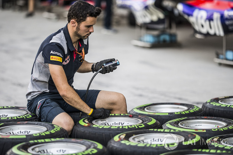 Механики Scuderia Toro Rosso работают с шинами