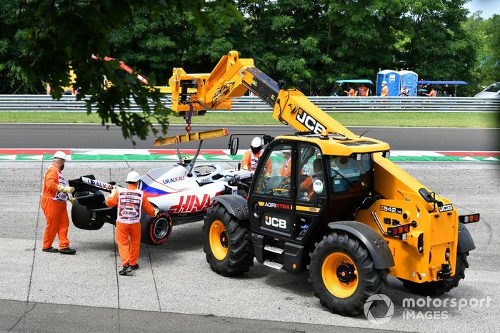 Los oficiales retiran el coche dañado de Mick Schumacher, Haas VF-21, de una barrera de neumáticos tras su accidente en la FP3
