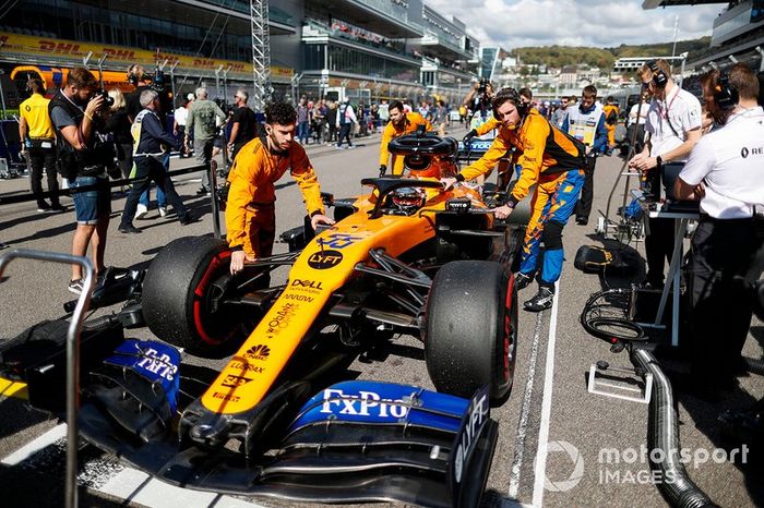 Carlos Sainz Jr, McLaren, llega a la parrilla con sus mecánicos