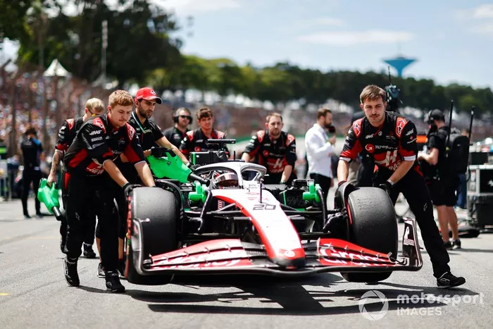 Los mecánicos llevan a Kevin Magnussen, Haas VF-23, a la parrilla de salida