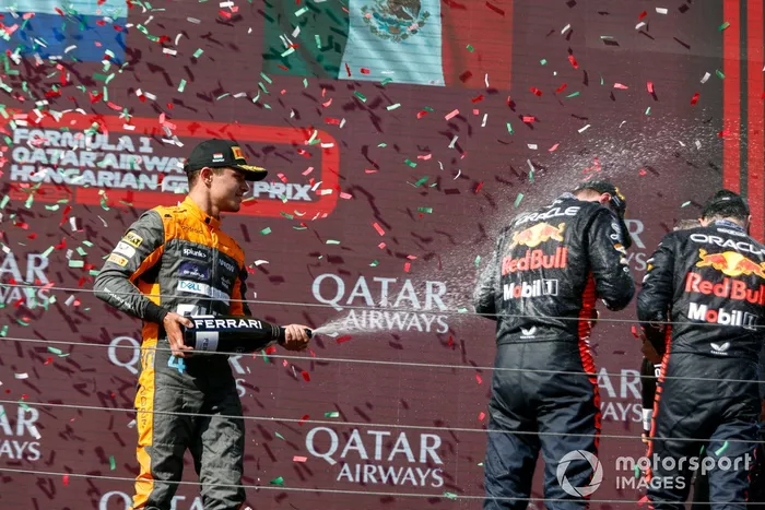 Lando Norris, McLaren, 2ª posición, rocía con champán a Max Verstappen, Red Bull Racing, 1ª posición, Sergio Pérez, Red Bull Racing, 3ª posición, en el podio.