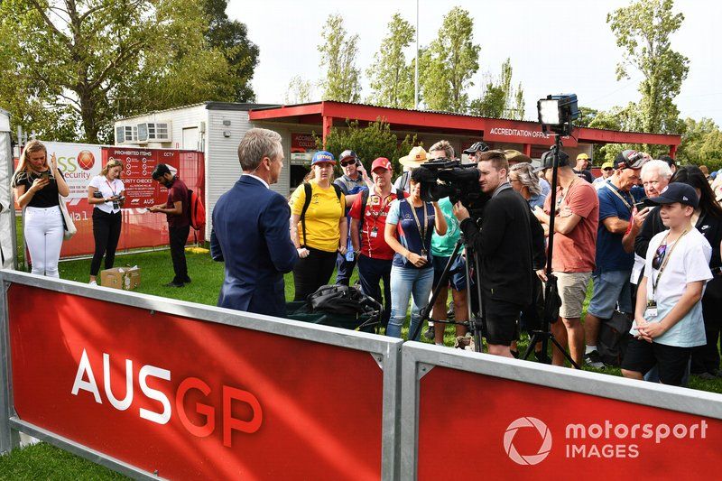 Un oficial habla a los medios mientras los fans escuchan