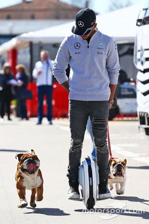 Lewis Hamilton, de Mercedes AMG F1 en un hoverboard en el paddock con sus perros Roscoe y coco
