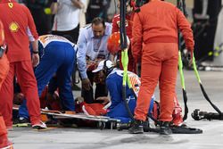 A Ferrari mechanic is tended by medics after being hit by the car of Kimi Raikkonen, Ferrari SF71H during a pit stop