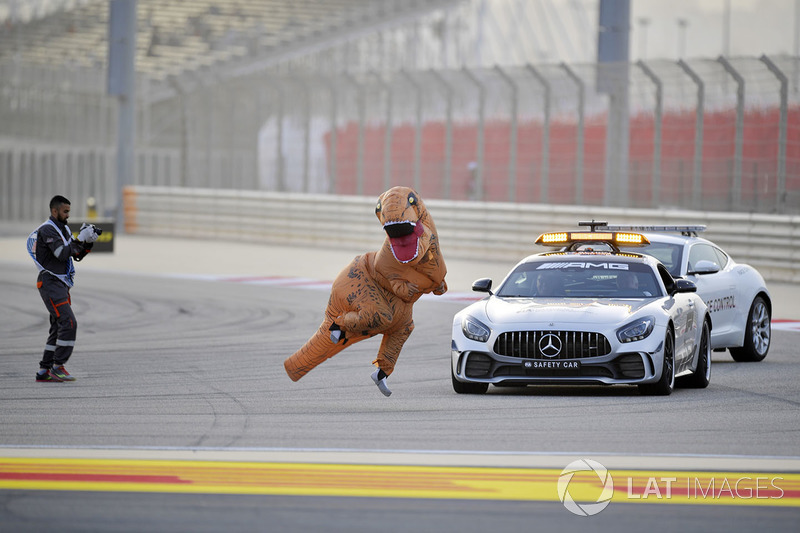 Oficiales con un mensaje para Charlie Whiting, delegado de la FIA en el auto de seguridad que involucra a un dinosaurio