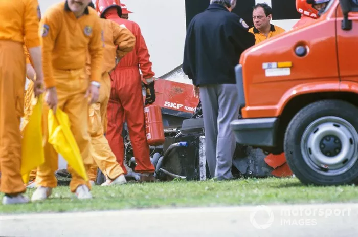 Marshals attend Gerhard Berger's Ferrari 640 after an accident