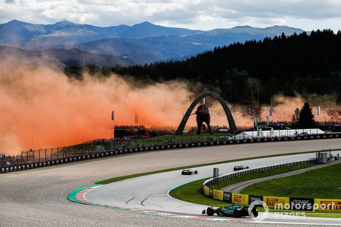 El humo naranja llena el aire mientras Lance Stroll, Aston Martin AMR22, Pierre Gasly, AlphaTauri AT03