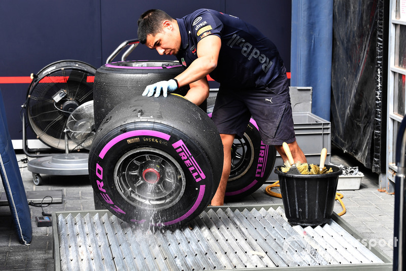 Des mécaniciens Red Bull Racing nettoient des pneus Pirelli