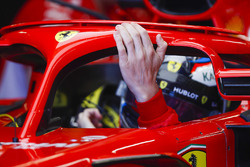 Kimi Raikkonen, Ferrari, rests a hand on his halo