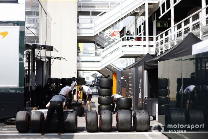 Mechanics wash tyres in the paddock
