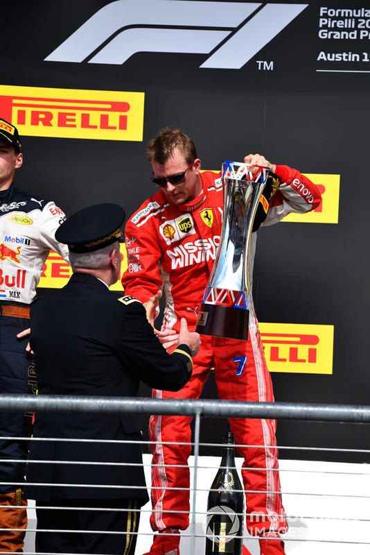 Kimi Raikkonen, Ferrari receives the race winners trophy on the podium