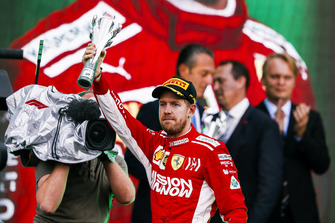 Sebastian Vettel, Ferrari, 2nd position, lifts his trophy on the podium