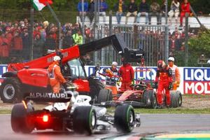 Yuki Tsunoda, AlphaTauri AT03, passes as Marshals assist Carlos Sainz Jr., Ferrari F1-75, in the gravel