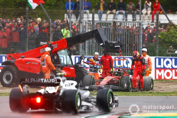 Yuki Tsunoda, AlphaTauri AT03, pasa mientras los comisarios asisten a Carlos Sainz Jr., Ferrari F1-75, en la grava