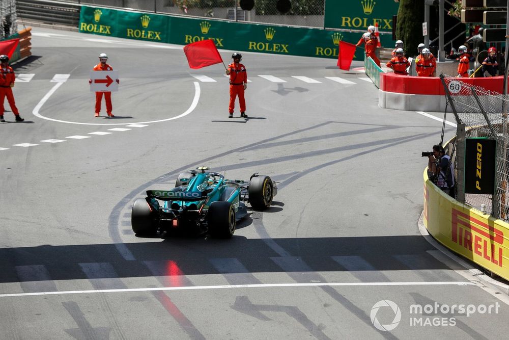 Fernando Alonso, Aston Martin AMR23, passes a marshal with red flags