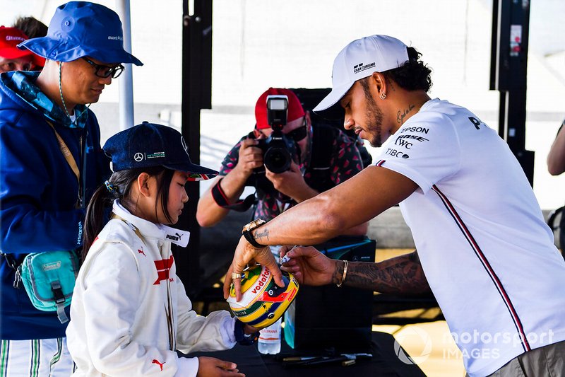 Lewis Hamilton, Mercedes AMG F1 signs a mini helmet for a fan
