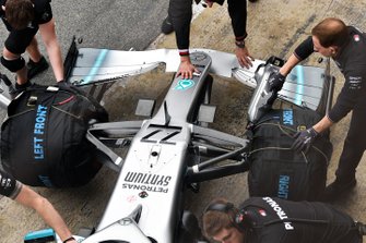 I membri del team spingono la monoposto di Valtteri Bottas, Mercedes AMG F1 W10, nel garage