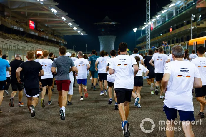 Sebastian Vettel, Aston Martin, es acompañado en una carrera alrededor del circuito por los miembros del equipo con la playera de Danke Seb como parte de su despedida en su último Gran Premio