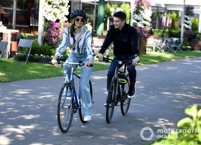 Charles Leclerc, Ferrari, monta una bicicleta en la pista con su novia Charlotte Sine