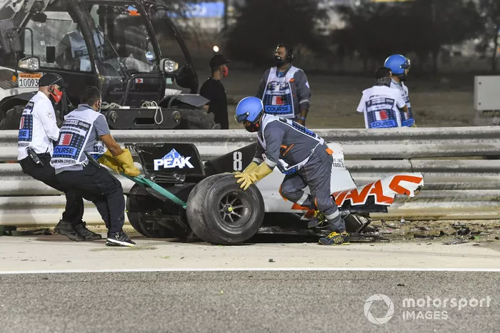 Los oficiales retiran los restos del monoplaza de Romain Grosjean, Haas VF-20, después del accidente en la primera vuelta