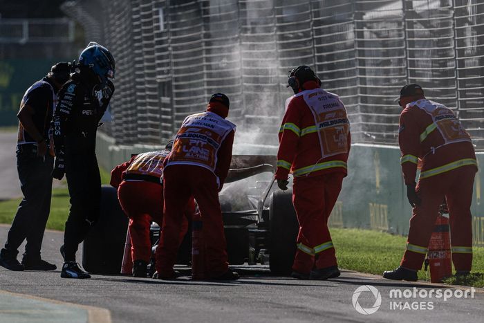 Los comisarios asisten a George Russell, Mercedes F1 W14, después de que un incendio provocara su retirada.