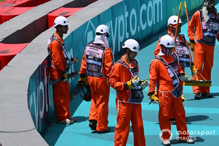 Los comisarios retiran el coche de Lando Norris, McLaren MCL38, después de que hiciera un trompo en la primera vuelta