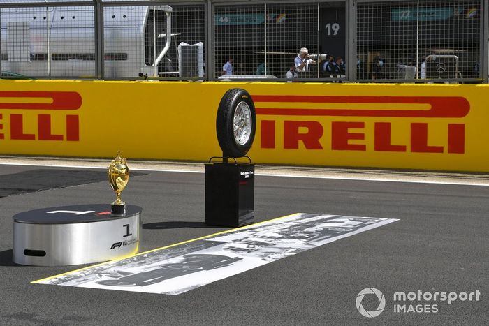 El trofeo y un neumático de la primera carrera en la parrilla antes de la salida