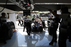 I membri del team spingono Jenson Button, McLaren nel box
