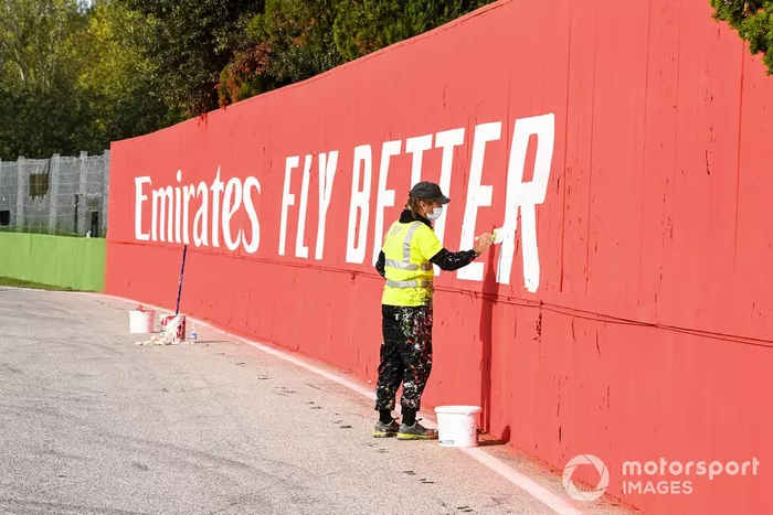 Un pintor retoca carteles de patrocinadores