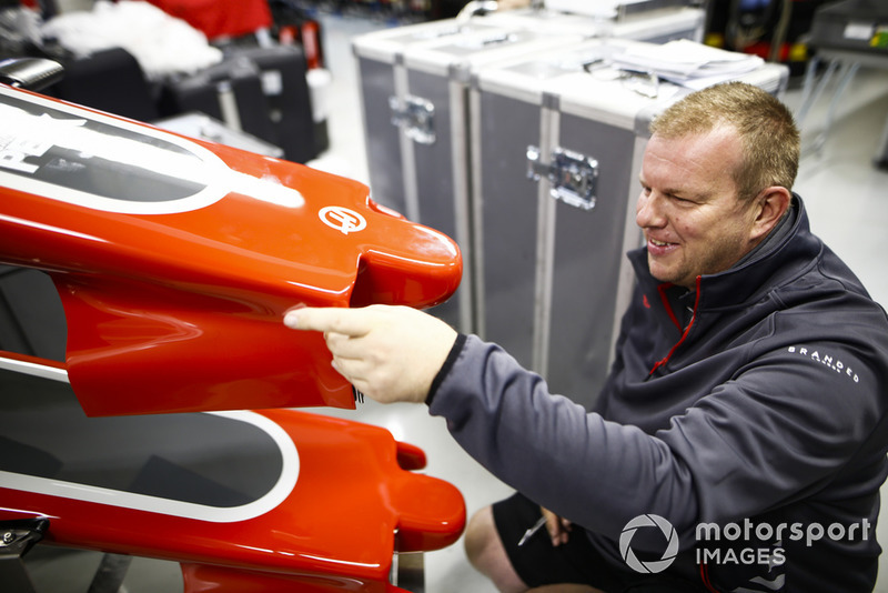 A Haas team member works on a nose cone