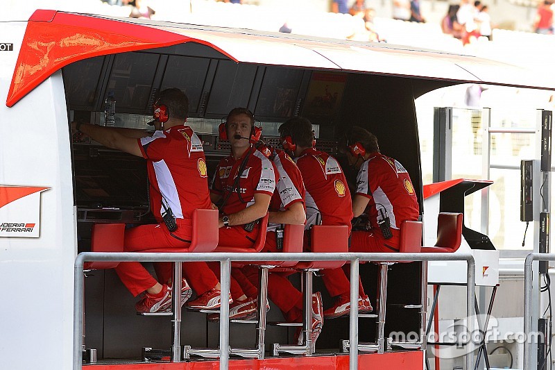 Ferrari team members on the pit wall