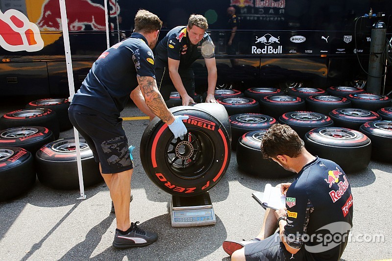 Red Bull Racing mechanics weigh a Pirelli tyre