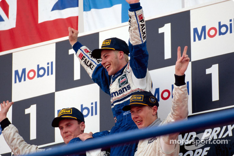 Le podium: le Champion du Monde Jacques Villeneuve avec David Coulthard et Mika Hakkinen