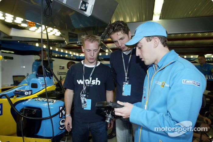 Fernando Alonso mostrándole al nadador Pieter van den Hoogenband y al patinador holandés de velocidad, Jochem Uytdehaage, el volante del Renault F1