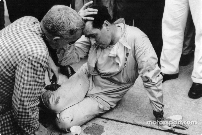 Jack Brabham takes a well-earned rest after pushing his Cooper-Climax half a mile to the finishing l