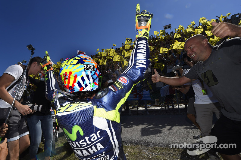 Race winner Valentino Rossi celebrates with fans