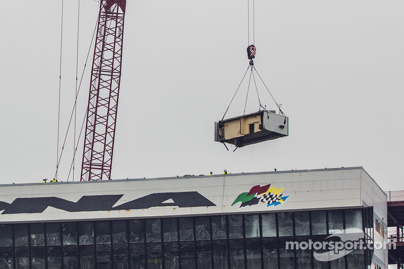 A crane takes away the first piece of the Daytona press box and suite facility