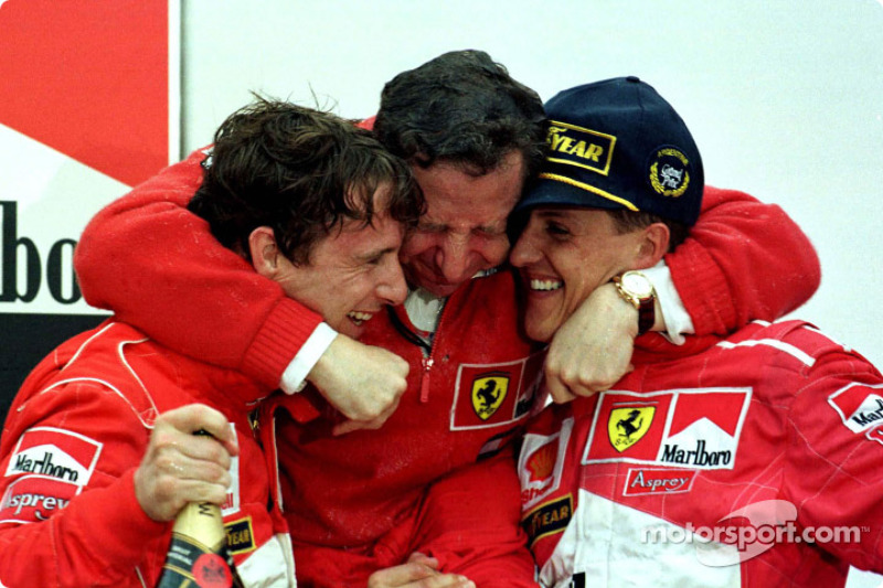 Podio: ganador de la carrera Michael Schumacher y Eddie Irvine de segundo lugar celebran con Jean Todt
