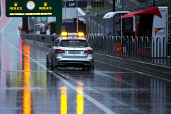 The FIA Medical Car drives through a wet and rainy pit lane