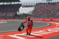 A marshal removes the tyre carcass of Sebastian Vettel, Ferrari