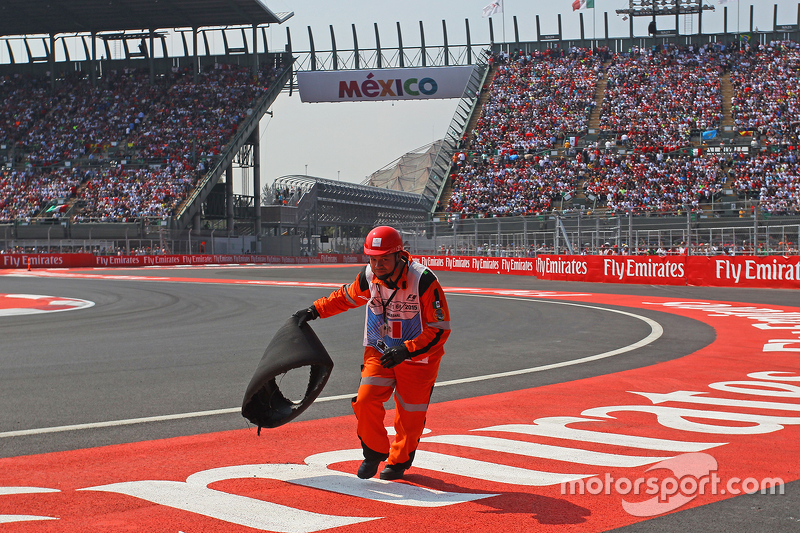 A marshal removes the tyre carcass of Sebastian Vettel, Ferrari