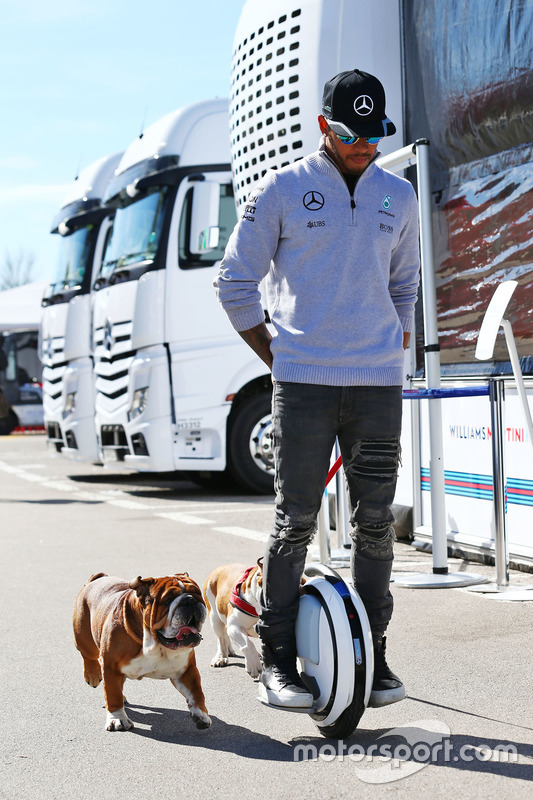 Lewis Hamilton, de Mercedes AMG F1 en un hoverboard en el paddock con sus perros Roscoe y Coco