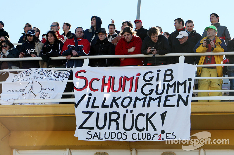 Aficionados observan la acción con una pancarta para Michael Schumacher, Mercedes GP